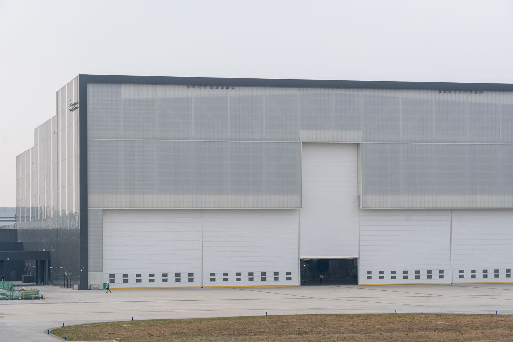 The front of a large gray industrial warehouse with closed loading doors.